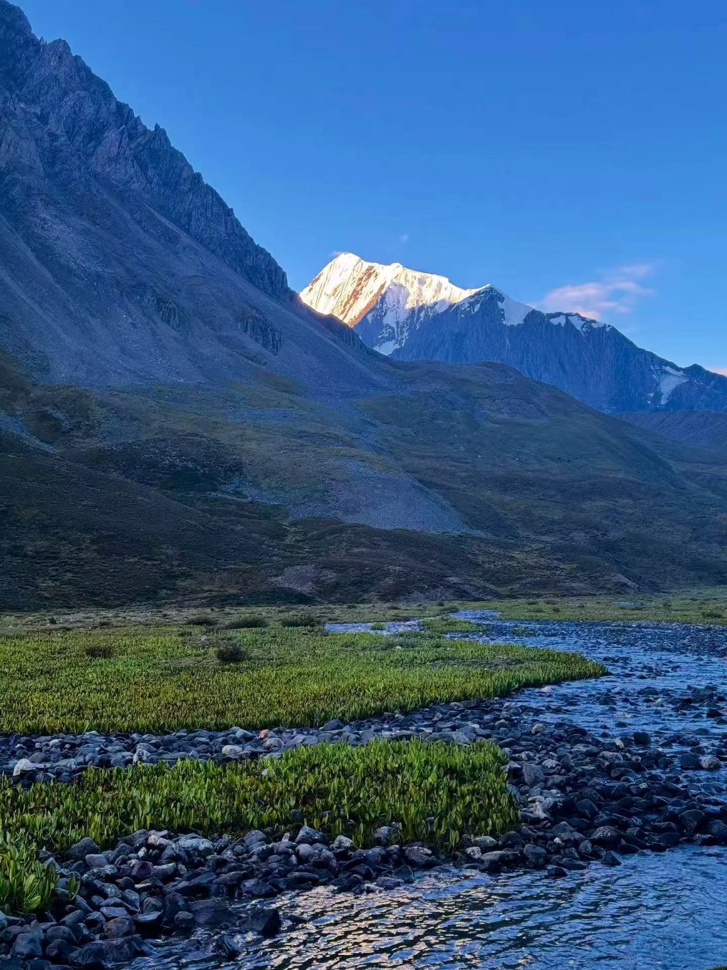 Mountain valley landscape with river and snow-capped peak at Le Mando